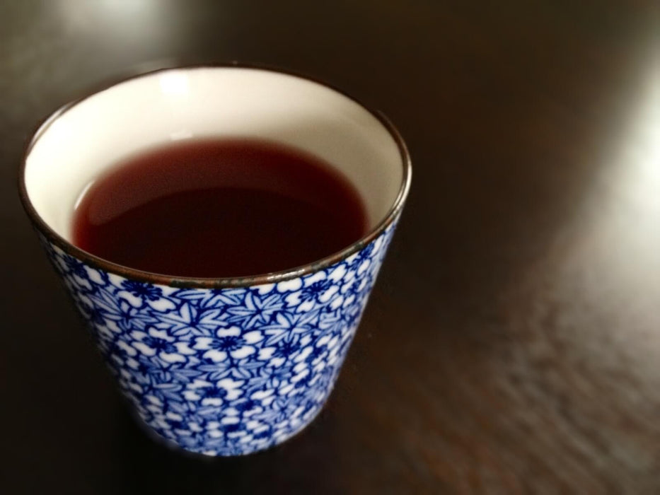 Flüssiger Pu-Erh-Tee in Teetasse mit blauen Mustern - Liquid Pu-Erh in teacup with blue pattern