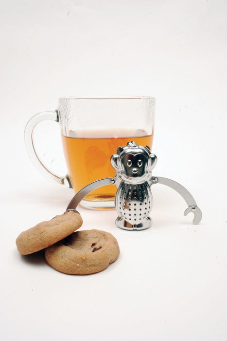Tee-Aufgusskorb Teegeschirr in Affenform neben einer Tasse Tee - Monkey Tea Infuser Teaware Kikkerland next to cup of tea