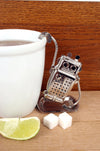 Teesieb teegeschirr in roboterform hängend an einer weissen Teetasse - Robot Tea Infuser Teaware hanging from white teacup
