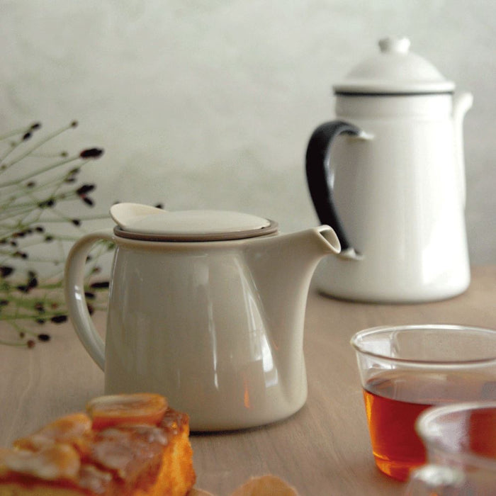 BRIM graue Edelstahl Teekanne neben transparenten Tee Kasse - Stainless Steel BRIM teapot next to transparent teacups on a wood table Teaware Kinto